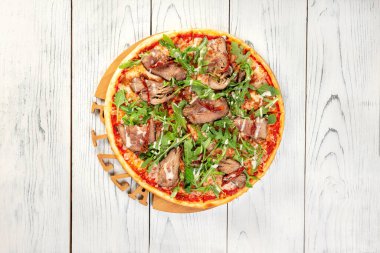 Ahşap arka planda biftekli pizza, fotokopi alanı olan üst manzara..