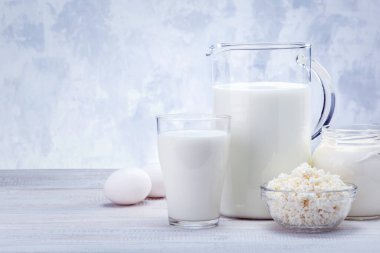 Beyaz ahşap masa üzerinde kopyalama alanı olan çeşitli mandıra ürünleri.