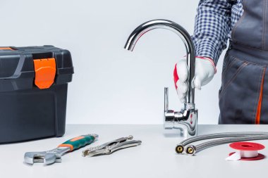 Musluklu musluk, alet çantalı, masada aletler ve aletler var. Tesisat Hizmetleri Konsepti. Kurulum Su Musluğu.