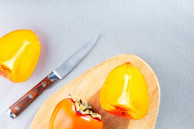 Taze hurma, kesim tahtasında hurma parçaları, masada fotokopi alanı olan bıçak. Üst Manzara. Doğal vitamin yiyeceği..