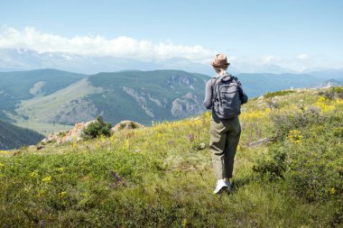 Sırt çantalı bir kadın dağda yürüyüş yapıyor. Aktif insan yaşam tarzı yürüyüşü sırt çantası takmak dışarıda egzersiz yapmak..
