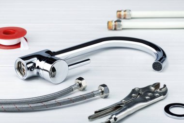 Beyaz fayans üzerindeki bağlantı için musluk ve çeşitli ayrıntılar.