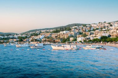 Gün batımında Bodrum sahilinin, yelkenlilerin, yatların ve otellerin güzel manzarası. Yaz tatili kavramı.
