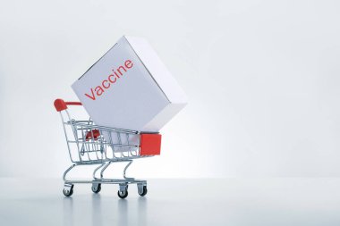 Tramvayda COVID-19 Coronavirus hastalığı aşısıyla dolu bir kutu. Açık gri arka planda fotokopi alanı var. Covid-19 Coronavirus aşısı nakil ve dağıtım kavramı.