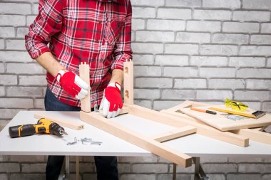 Mobilya kurulumu. Marangoz sandalyeyi monte etmekle meşgul. Diy kavramı.