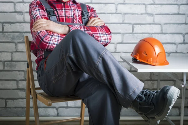 Striking worker on workplace. Worker on strike against brick wall background. Work refusal concept.