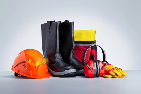 Personal protection equipment on grey background. Safety at work concept.