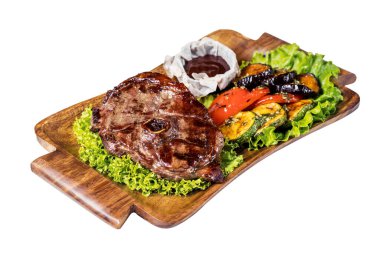 Tahta tabakta sebzelerle ızgara edilmiş biftek, beyazda izole edilmiş..