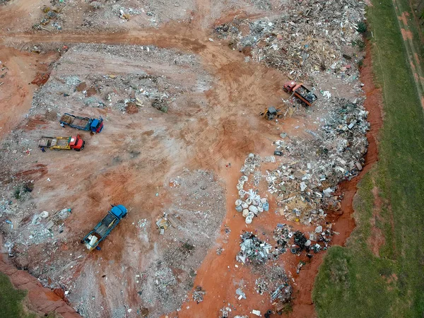 Aerial view made by drone of trucks unloading debris at the Landfill in Brazil