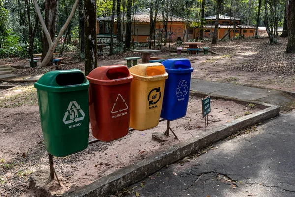 Four color trash cans for recycle, next to a sign written \