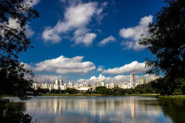 Ufuk çizgisi Brezilya 'nın Sao Paulo şehrindeki Ibirapuera Parkı' ndaki gölün sakin sularını yansıtıyor.