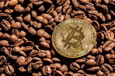 Brezilya 'da kavrulmuş kahve çekirdekleriyle arka planda altın bitcoin.