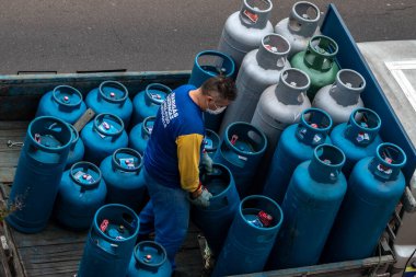 Marilia, Sao Paulo, Brezilya, Mayıs 07, 2021. Yükleyici, Sao Paulo eyaleti Marilia 'daki evler için küçük bir LPG gaz taşıyıcı kamyonunda çalışıyor.
