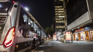 Sao Paulo, Brezilya, 21 Mayıs 2021. İnsanlar ve otobüsler geceleyin Sao Paulo 'daki Paulista Bulvarı' nda dururlar..