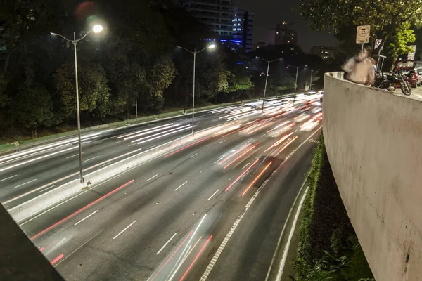 Sao Paulo, Brazil, July 27 , 2021. Night time lapse of vehicles and pedestrians traveling along the Santa Generosa Viaduct and heavy traffic on 23 de Maio Avenue.