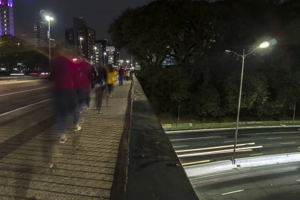Night time lapse of vehicles and pedestrians traveling along the Santa Generosa Viaduct and heavy traffic on 23 de Maio Avenue.
