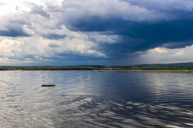 Brezilya, Paranapanema Nehri 'nde dramatik bir birliktelik. Farklı renklerdeki sular, güçlü fırtınalı bir gökyüzünün altında birleşerek doğanın zıtlığını ve gücünü gösterir..