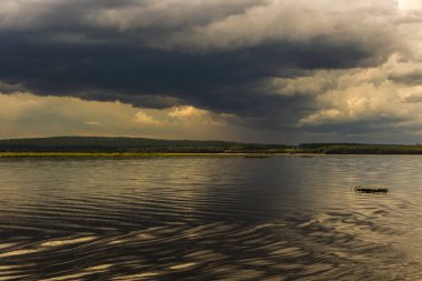 Brezilya, Paranapanema Nehri 'nde dramatik bir birliktelik. Farklı renklerdeki sular, güçlü fırtınalı bir gökyüzünün altında birleşerek doğanın zıtlığını ve gücünü gösterir..