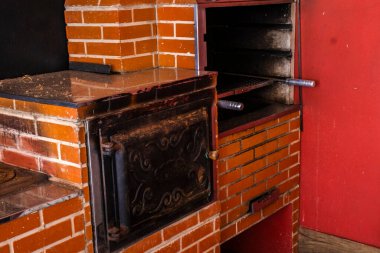 Geleneksel ahşap fırını, klasik dökme demir kapısı ve açık ızgara ocağı olan taşralı tuğla yapısı Brezilya mutfak geleneklerini somutlaştırıyor..