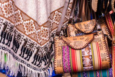 And el sanatları: Geometrik desenli yün panço ve geleneksel And figürlü deri çantalar. Canlı renkler Bolivya kültürünü yansıtır.