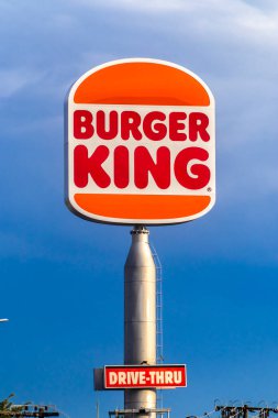 Marilia, SP, Brezilya. 23 Kasım 2025. Sembolik Burger King logosu bulutlu mavi gökyüzüne karşı dimdik ayakta duruyor. Küresel fast-food endüstrisinin ve Amerikan kültürünün dünya çapında bir sembolü..