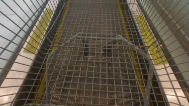 Travelator 'daki boş metal alışveriş arabasının POV' u ya da hareket halindeki yürüyüş yolu, üst manzara. Metal araba vagonu..