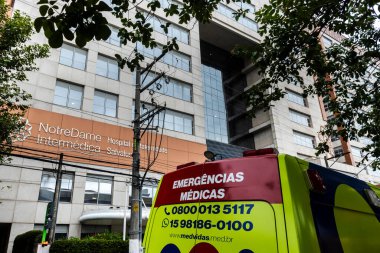 Sao Paulo, SP, Brezilya, 17 Aralık 2025. Portekizce, Alvalus Hastanesi 'nin önünde, Brezilya' daki bir şehir ortamında sağlık hizmetlerini tasvir eden tıbbi acil durum yazılı bir ambulans..