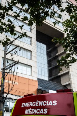 Sao Paulo, SP, Brezilya, 17 Aralık 2025. Portekizce, Alvalus Hastanesi 'nin önünde, Brezilya' daki bir şehir ortamında sağlık hizmetlerini tasvir eden tıbbi acil durum yazılı bir ambulans..