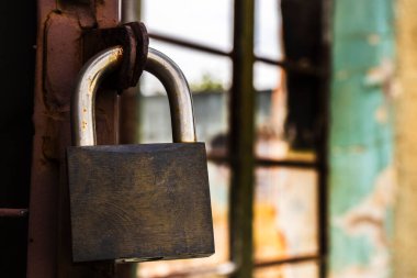 Brezilya 'da eski bir pencerede asma kilit. Güvenlik sembolü çürümeyle çelişiyor. Pas ve soyulmuş boya bize zamanın ve terk edilmişliğin hikayesini anlatır..