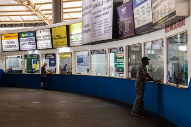 Marilia, SP, Brezilya. 26 Eylül 2025. Marilia 'daki otobüs terminalinin bilet gişesindeki yolcular, SP. Çeşitli şirketler için işaretler büyük şehirlere giden yolları gösteriyor.