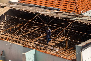 Marilia, Sao Paulo, Brezilya, 14 Ekim 2025. Marilia 'nın merkezindeki ticari bir noktanın çatısını yenilemek için bir eve metal çarşaf döşeyen bir işçinin üst görüntüsü.