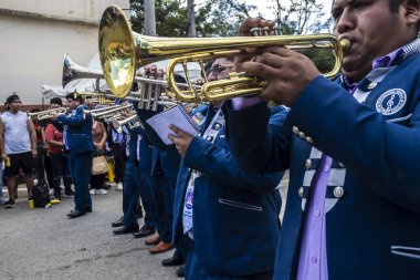 Sao Paulo, Brezilya, 12 / 21 / 2025. Bando, Kantuta Meydanı 'nda konser veriyor. Mavi üniformalı müzisyenler, bir Bolivya sokak fuarı sırasında zengin kültürel çeşitliliği yansıtan rüzgar enstrümanları çalıyorlar.
