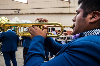 Sao Paulo, Brezilya, 12 / 21 / 2025. Bando, Kantuta Meydanı 'nda konser veriyor. Mavi üniformalı müzisyenler, bir Bolivya sokak fuarı sırasında zengin kültürel çeşitliliği yansıtan rüzgar enstrümanları çalıyorlar.