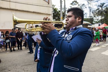 Sao Paulo, Brezilya, 12 / 21 / 2025. Bando, Kantuta Meydanı 'nda konser veriyor. Mavi üniformalı müzisyenler, bir Bolivya sokak fuarı sırasında zengin kültürel çeşitliliği yansıtan rüzgar enstrümanları çalıyorlar.