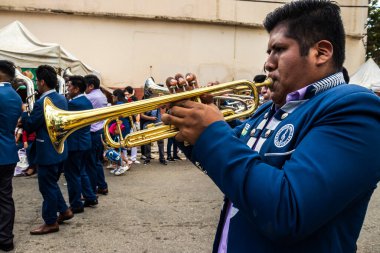 Sao Paulo, Brezilya, 12 / 21 / 2025. Bando, Kantuta Meydanı 'nda konser veriyor. Mavi üniformalı müzisyenler, bir Bolivya sokak fuarı sırasında zengin kültürel çeşitliliği yansıtan rüzgar enstrümanları çalıyorlar.