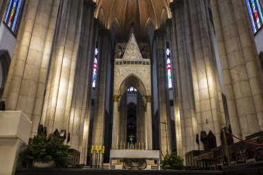 Sao Paulo, Brezilya, 12 / 21 / 2025. Sao Paulo Metropolitan Katedrali 'nin mihrabında merkezi bir haç, parlak mumlar ve görkemli Neo-Gotik sütunlar sergileniyor.