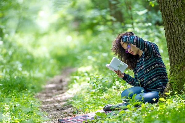 Piękne Młoda kobieta brunetka, czytanie książki w parku — Zdjęcie stockowe