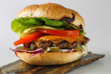 Lezzetli peynir sığır eti burger marul, çedar, Barbekü sos, marul, çedar, barbekü sosu, domates, turşu ve cacık ile lezzetli peynir sığır eti burger