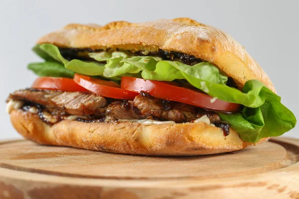 Lezzetli domuz biftek sandviç içinde bir ciabatta ile domates, marul