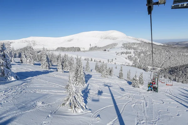 Esquiadores en telesilla, en un hermoso día soleado en las montañas de los Cárpatos —  Fotos de Stock