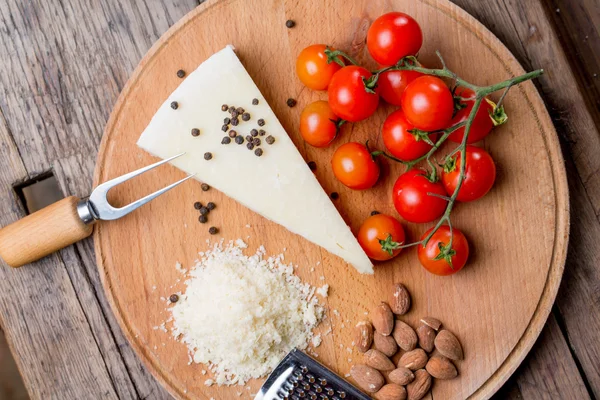 Rendelenmiş pecorino peyniri domates, seçici odak ile ahşap kesme tahtası üzerinde