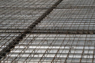 İnşaat yüzeyi beton dökmeye hazır. Çelik takviye çubuklarından (demir çubuk) oluşan yoğun bir ızgaraya sahiptir, kıvrımlı metal döşeme üzerine bağlanarak bir zemin levhası için yapısal taban oluşturur.