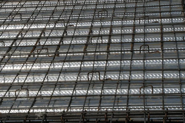 İnşaat yüzeyi beton dökmeye hazır. Çelik takviye çubuklarından (demir çubuk) oluşan yoğun bir ızgaraya sahiptir, kıvrımlı metal döşeme üzerine bağlanarak bir zemin levhası için yapısal taban oluşturur.