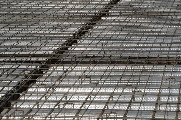 İnşaat yüzeyi beton dökmeye hazır. Çelik takviye çubuklarından (demir çubuk) oluşan yoğun bir ızgaraya sahiptir, kıvrımlı metal döşeme üzerine bağlanarak bir zemin levhası için yapısal taban oluşturur.