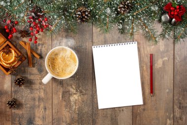 Bir fincan sıcak kakao ya da çikolata, tatil süslemeleri ve yukarıdaki ahşap vintage masaya listelenecek defter, noel planlama konsepti. Yeni yıl ve Noel 'le birlikte ahşap masadaki defter