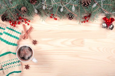 Kırmızı süslemeli, çam kozalaklı beyaz ahşap arka plandaki Noel köknar dallarından yapılmış yaratıcı çerçeve. Xmas ve Yeni Yıl teması. kopyalama alanı. en üstteki görünüm