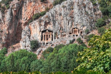 Kayadaki antik Lycia krallarının mezarları. Bir grup kaya kadim kralların mezarlarını kesiyor. Türkiye 'nin Mugla ilçesine bağlı Dalyan köyü yakınlarındaki Kaunos kasabasının Lycian mezarları