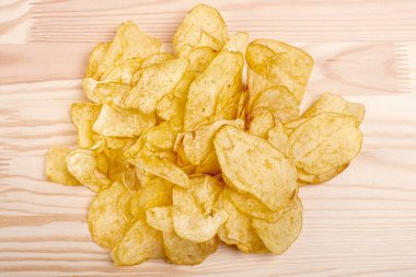 Patates cipsi Tahta bir masada patates cipsi yığını. Çıtır patates cipsi. abur cubur kavramı