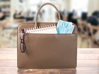 Tıbbi maskeli bir iş çantası. İş yerinde, eğitimlerde, toplantılarda ve iş toplantılarında koronavirüs enfeksiyonuna karşı korunma. yüz koruma maskesi