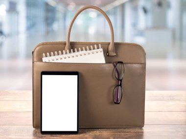 Boş ekran ile Dijital Tableti Uygula. Çanta ile çalışma alanı, iş çantası, ahşap ofis masasındaki boş dijital tablet